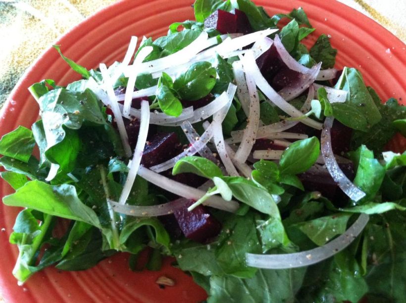 Closeup of arugula salad with basil trimmings