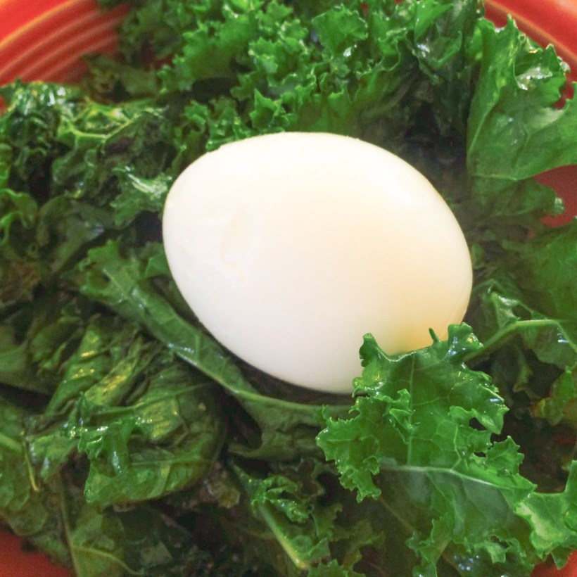 Soft boiled egg on sautéed kale